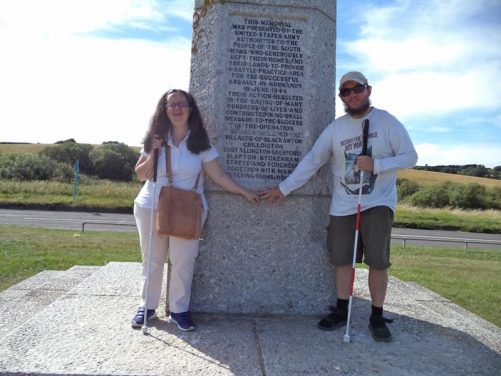 Close-up of Tony and Tatiana in front of a memorial at Slapton Sands.